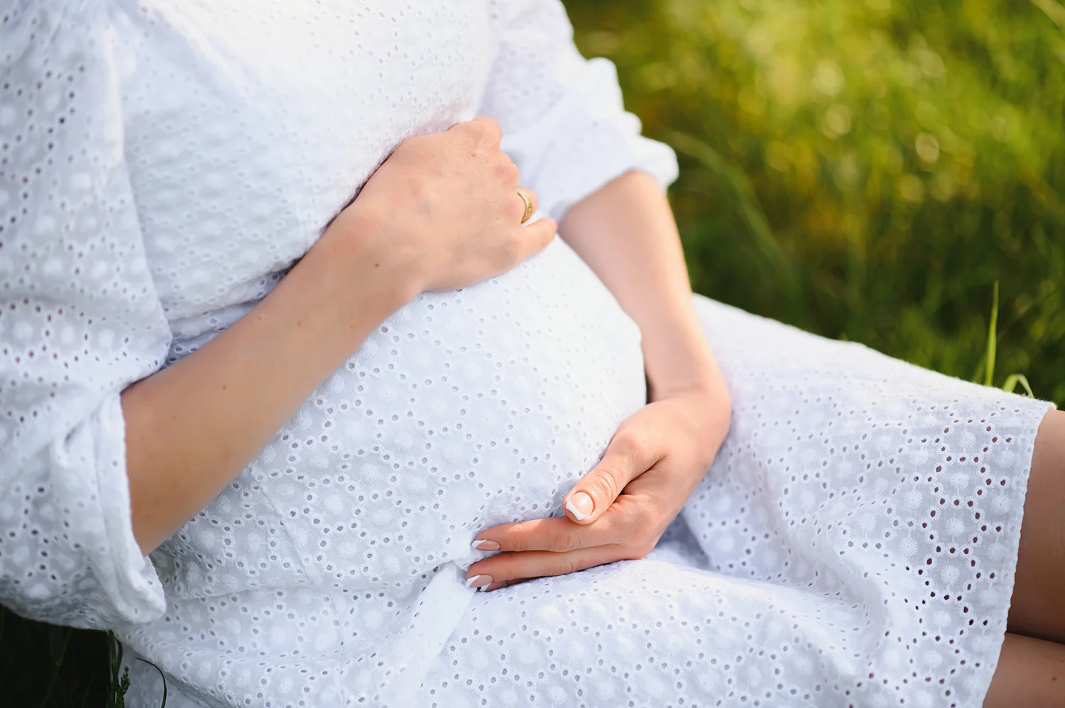 close up of pregnant woman with hands on her belly